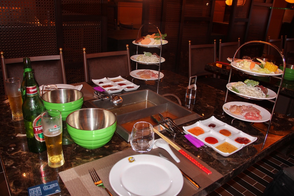 Das Abendessen im „Hot Pot“-Restaurant ist mit seinen vielen Saucen, Brühen und Beilagen eine Symphonie für alle Sinne – chinesisches Bier inbegriffen