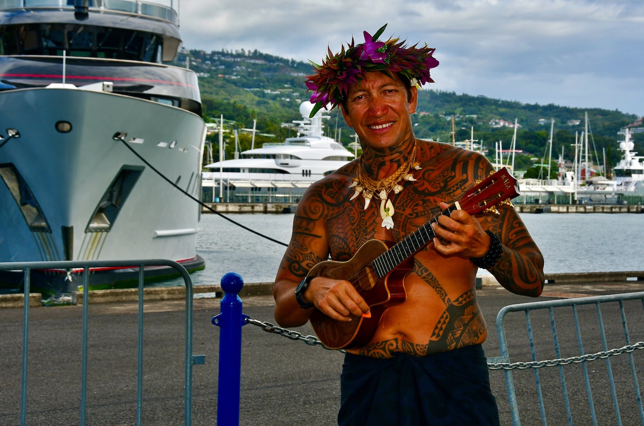 Mit traditionellen Klängen begrüßt der reich tätowierte Musiker die Gäste der Paul Gauguin im Hafen von Papeete