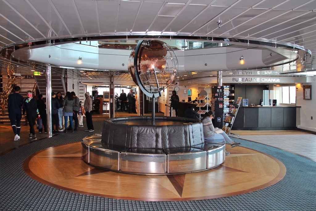 Das Atrium mit der zentralen Sitzgruppe und der Weltkugel auf Deck 7 ist Treff- und Anlaufpunkt für Passagiere aus aller Herren Länder an Bord
